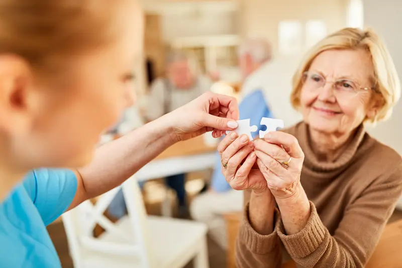 Ältere Frau setzt ein Puzzle zusammen
